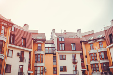 New multi-storey residential building. Modern house dyed in red and orange colors