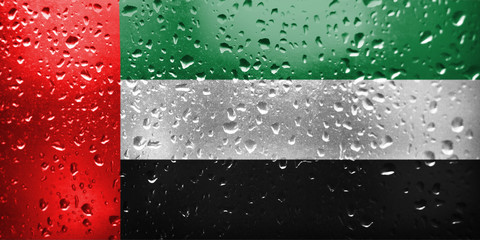Texture of the United Arab Emirates on the glass with drops of rain. 