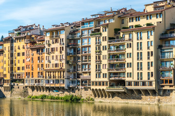 Fototapeta na wymiar Colorful old buildings line the Arno River in Florence, Italy