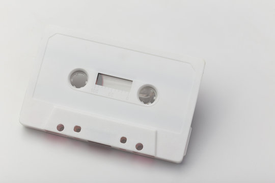 white audio cassette with pink film on white background