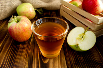 Apple  juice in the glass on the  brown wooden background