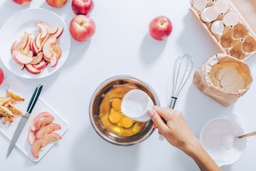 Cooking apple pie process: woman add sugar into bowl