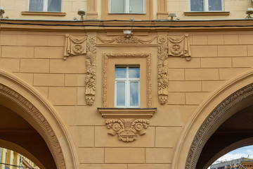 Window between two arches decorated with decorative bas-reliefs of the Soviet era