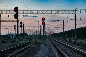 railroad traffic lights and infrastructure during beautiful sunset, colorful sky, transportation...