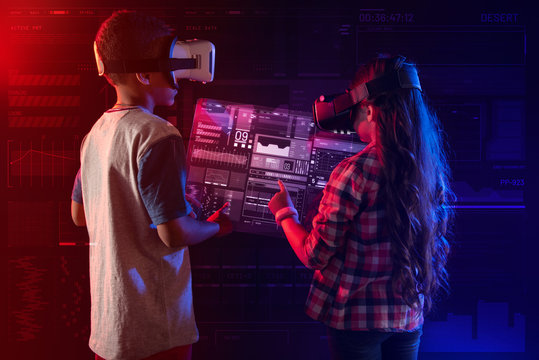 More information. Cheerful emotional kids putting their hands up and wearing virtual reality glasses while having fun with their new educational program