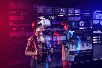 Progressive pupils. Modern kids feeling happy and enjoying their progressive computer studies lesson while wearing virtual reality glasses at school