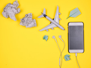 Smartphone, headphones, plane toy, paper plane and tossed paper