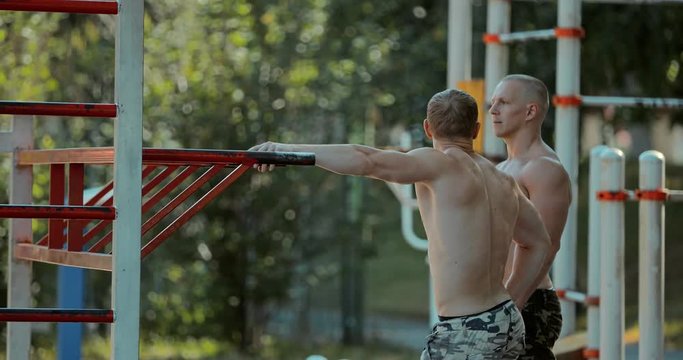 Strong muscled jocks talk at the sports ground on the outdoors
