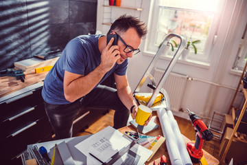 Men renovating kitchen and using smart phone
