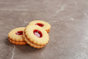 Traditional Christmas Linzer cookies with sweet jam on grey background