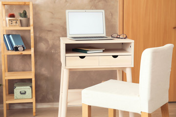 High wooden table with laptop as stand up workplace in modern interior