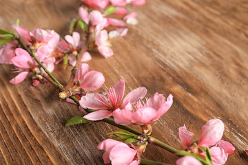 Beautiful blossoming branches on wooden background, closeup