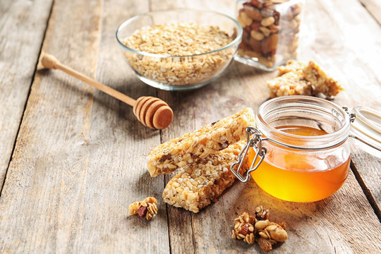 Homemade grain cereal bars and honey on wooden table. Healthy snack - Powered by Adobe