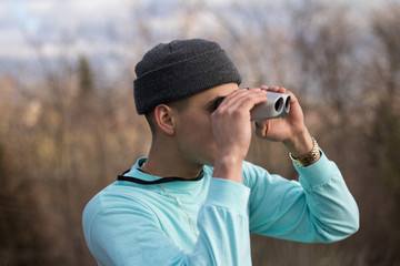 man in aqua coloured shirt looking through binoculars - 214147748