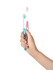 Woman holding manual toothbrushes against white background
