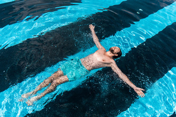 bearded man floating in swimming pool