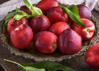 red ripe peaches nectarine in an iron plate
