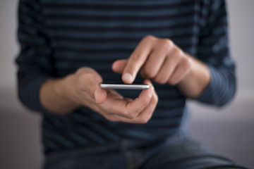 Young man using a touchscreen smartphone - Hands close-up - Using technology