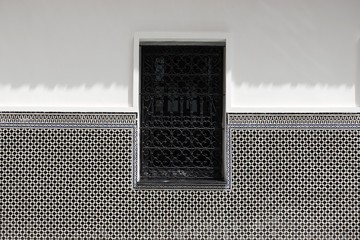 Fenêtre avec grille à motifs orientaux en fer forgé