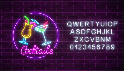 Neon cocktails bar sign with alphabet and two glasses of cocktails. Glowing gas advertising with glasses of alcohol.