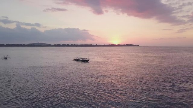Aerial view of a sunset over the ocean and boat