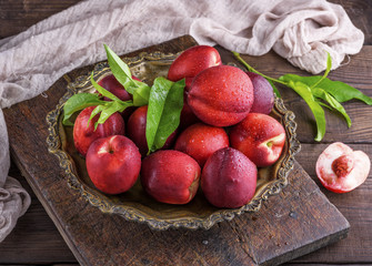 red ripe peaches nectarine in an iron plate