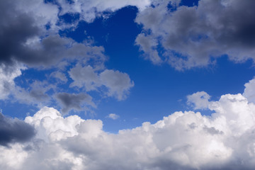Blue sky with storm clouds. Rain clouds are illuminated by the rays of the setting sun.