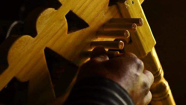 Hands tuning traditional harp.