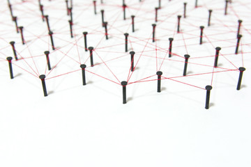 Linking entities, social media, Communications Network, The connection between the two networks. Network simulation on white paper linked together created by black nail and red thread