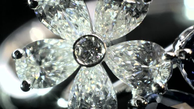 Close-up shot of two sparkling,shining white and blue flower shaped ring with diamonds and saphire jewelery.