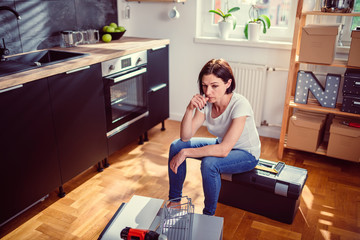 Worried woman renovating kitchen
