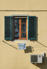 Laundry hanging below a shuttered window
