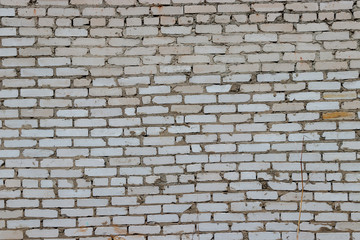 Background of sloppy folded white brick wall. Between the bricks a lot of extra cement