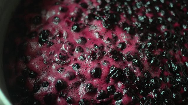 Tasty sweet black currant jam cooked on the stove.