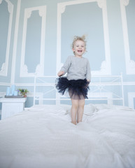 naughty little girl jumping on parent's bed.