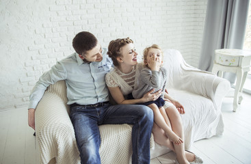 portrait of happy family sitting on sofa in living room