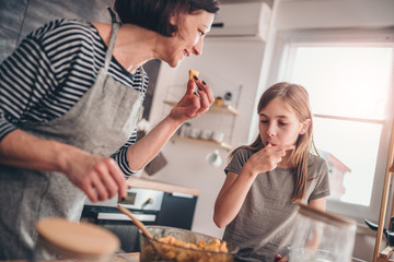Mother and daughter tasting apple pie filling