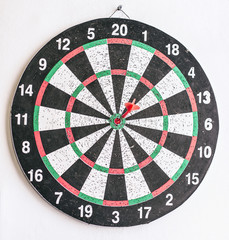Close up shot red dart arrow on center of dartboard