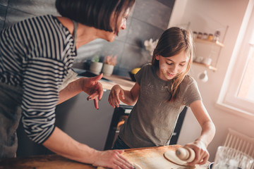 Mother and daughter making apple pie and having fun