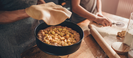 Mother and daughter placing top pie crust dough