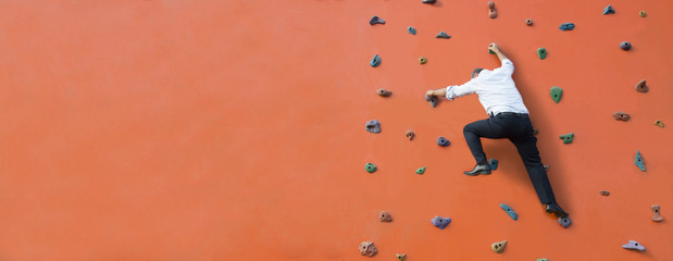 suit businessman climbs over the orange wall,