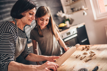 Mother and daughter filling ravioli with chocolate cream