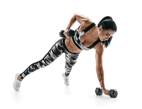 Beautiful athletic woman doing exercise with dumbbells. Photo of sporty latin woman in military sportswear isolated on white background. Strength and motivation.