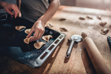 Woman putting pastry in baking tray