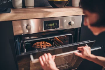 Foto op Plexiglas Woman checking apple pie in oven © kerkezz