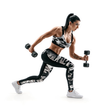 Sporty woman training muscles of hands and legs using a dumbbells. Photo of muscular latin woman in military sportswear isolated on white background. Strength and motivation. Side view
