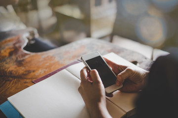 Woman reading good news on mobile phone during rest in coffee shop, happy female watching her photo on cell telephone while relaxing in cafe during free time