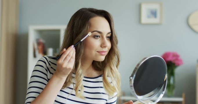 Young pretty beauty blogger woman teaching how to do make upp for eyes in her tutorial video. Inside.