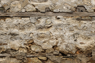Old rock wall covered with plaster in the traditional way
