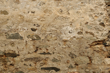 Old rock wall covered with plaster in the traditional way